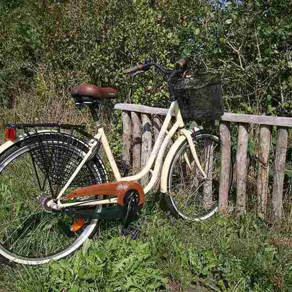 Cykelställ i trä med en vit cykel.