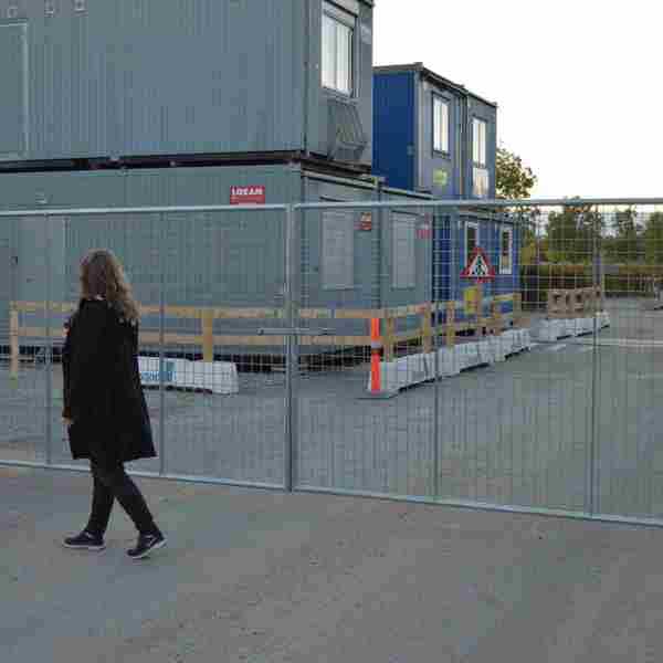 En kvinna går framför en lättviktsgrind som installerats på en byggarbetsplats